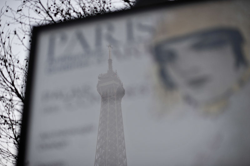 A reflection of the Eiffel tower in a display sign with the words Paris clearly visible